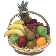 Корзина фруктов с апельсинами, лимонами, яблоками, ананасом и виноградом