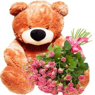 Big teddy bear with bouquet of spray roses