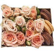 A bouquet of roses in a box with macarons